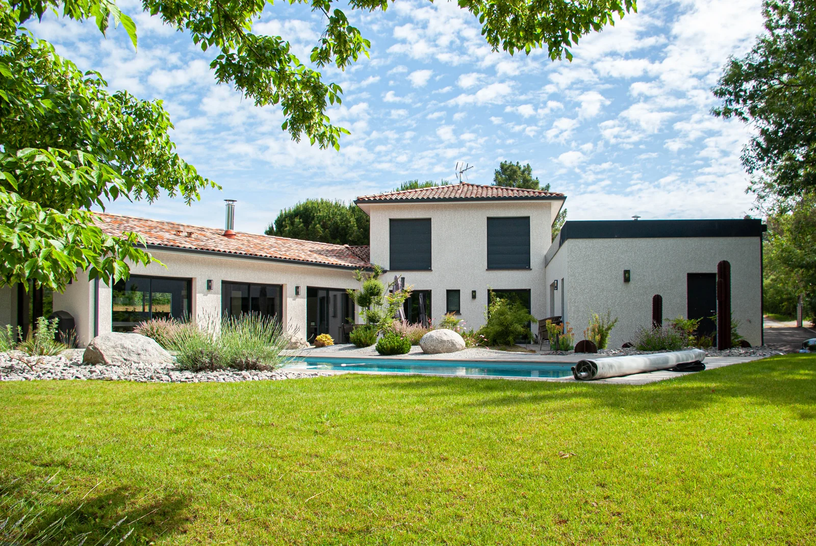 Maison CELIA associant un volume central à étage, deux ailes de plain-pied et un jardin arboré.